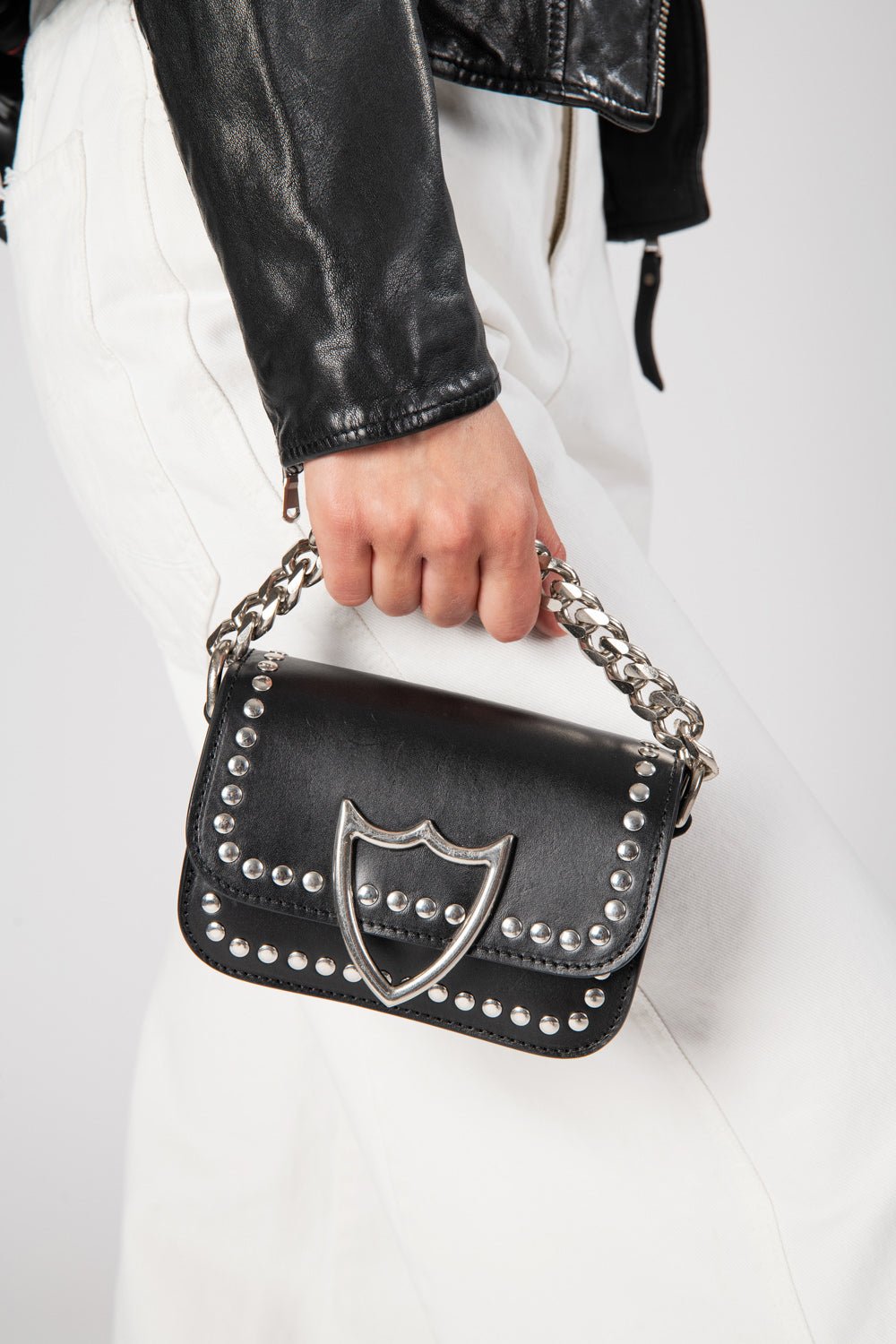 L.A. STUDS MICRO BAG Leather micro bag. Front studded flap with snap button closure. Front silver colored metal logo detail. One internal patch pocket. Leather lining. Shoulder leather strap and metal chain little strap. Made in Italy. 100% Leather. Lengh